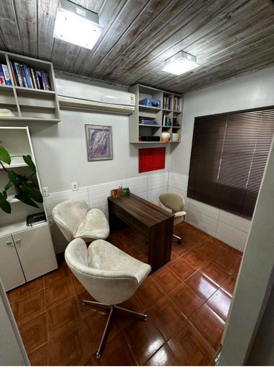 Sala de Atendimento 1 — sala privativa com mesa executiva, cadeiras e estantes em Guaíba/RS
