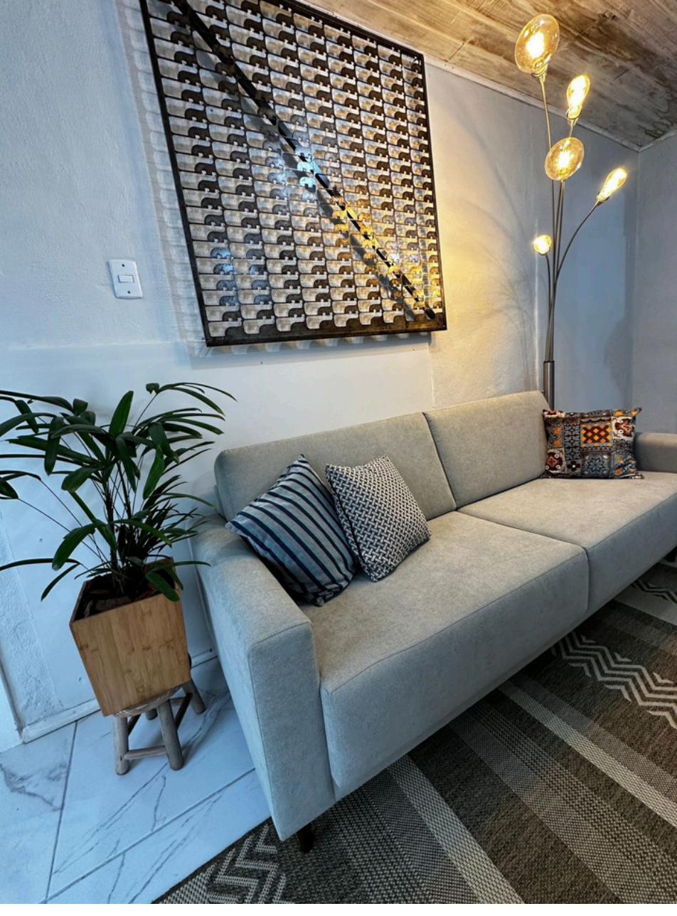 Sala de estar do Salus Coworking com sofá moderno e decoração elegante em Guaíba/RS